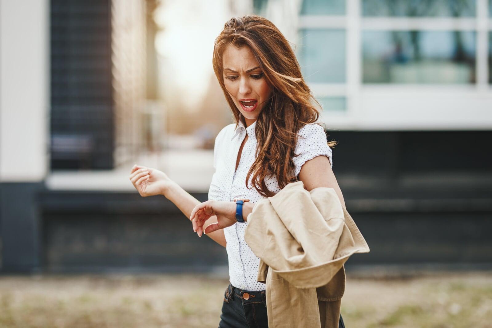 Frustrated customer looking at their watch while standing in a retail store queue